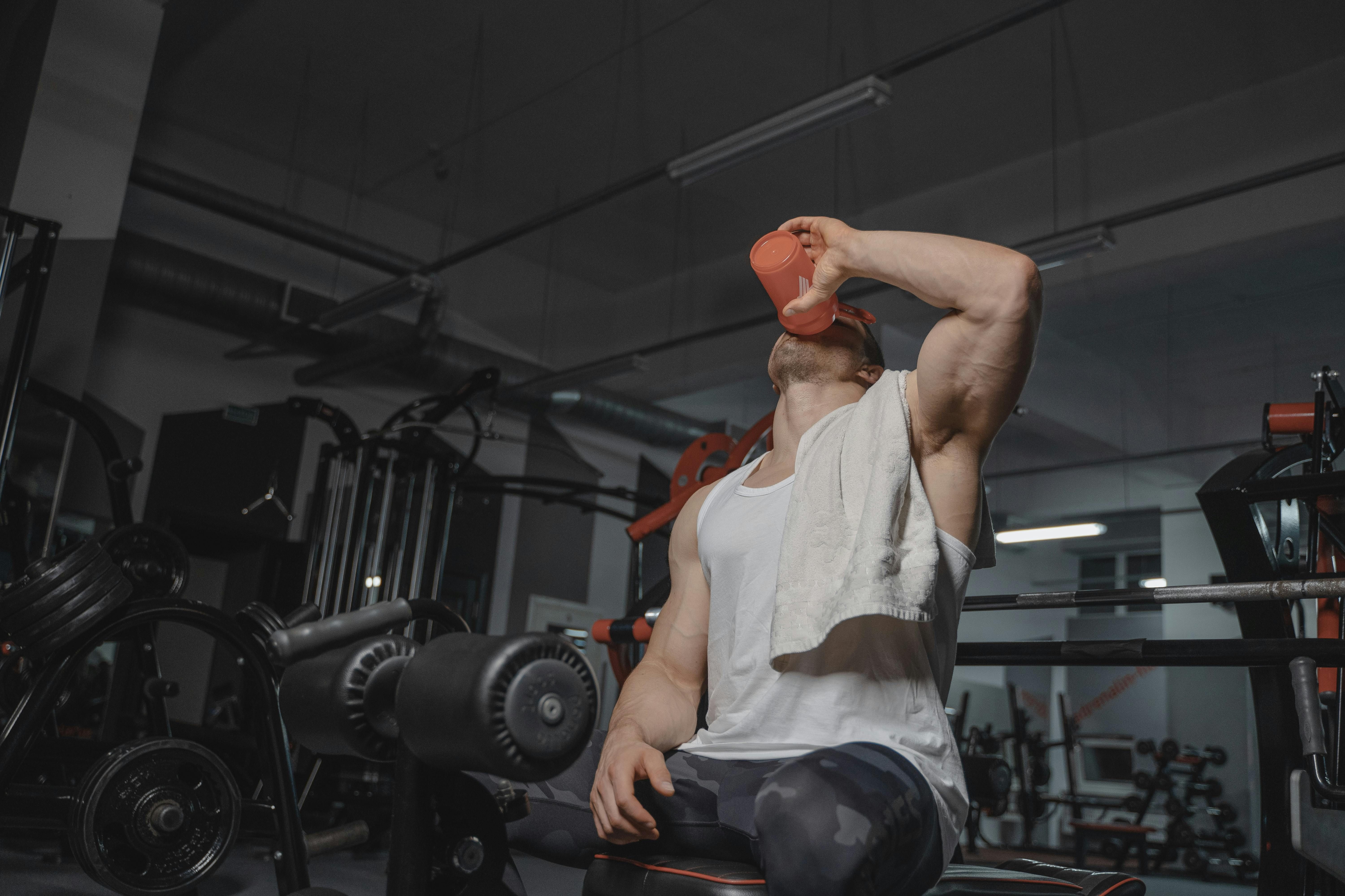 Strong guy at the gym drinking a protein drink